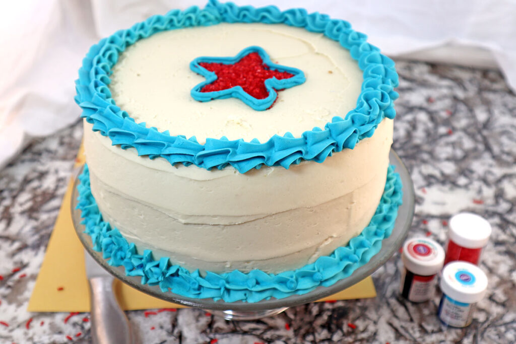 Frosted Round Cake with White Blue and a Red Star on Top